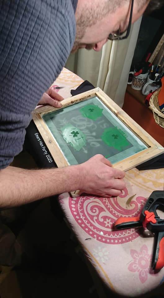 Johnny screen printing a design onto a t-shirt