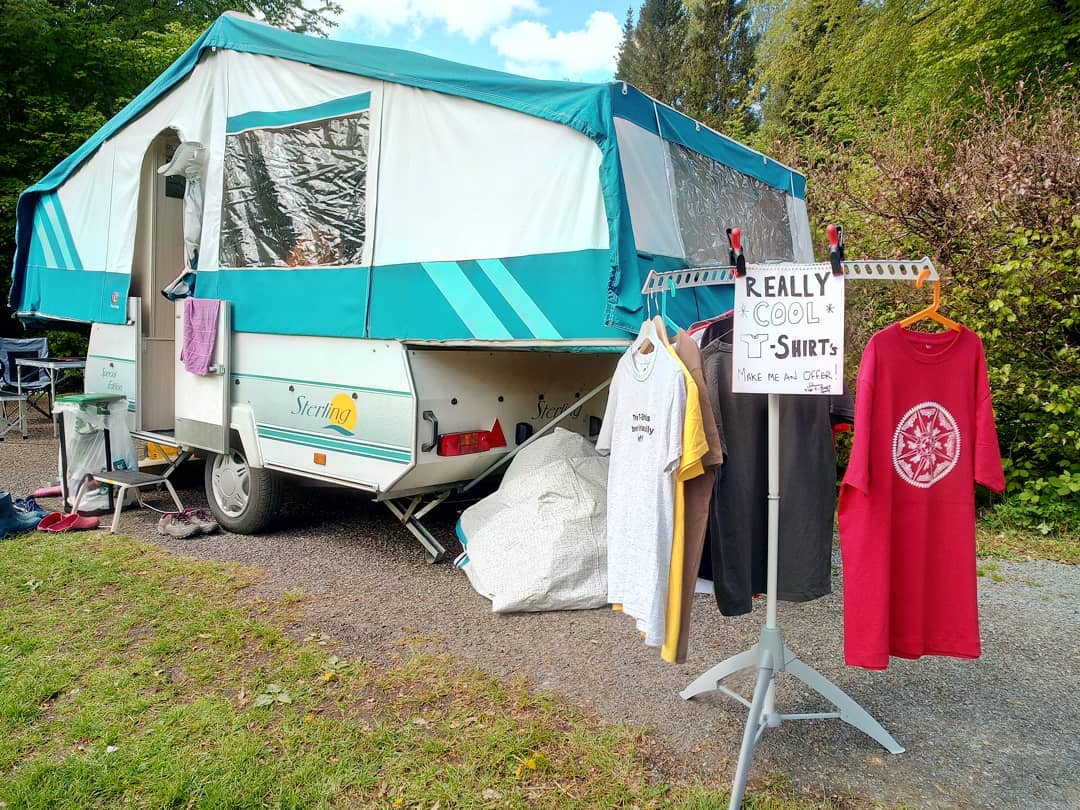 Trailer with some t-shirts for sale on campsite